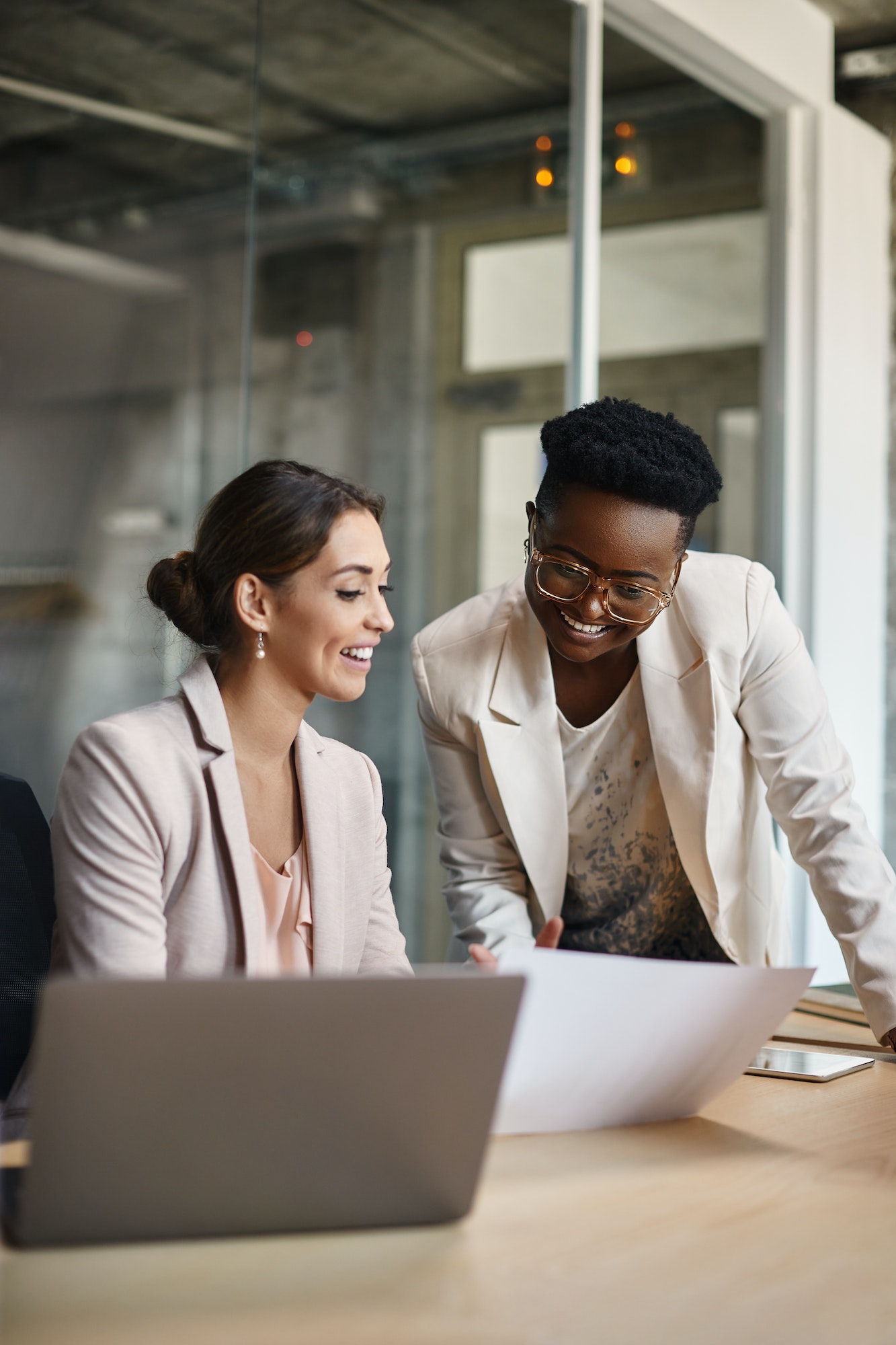 Happy black businesswoman and her colleague working on new ideas in the office.